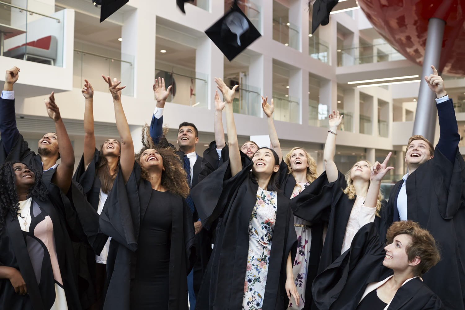 Alumnos lanzando gorras en graduación