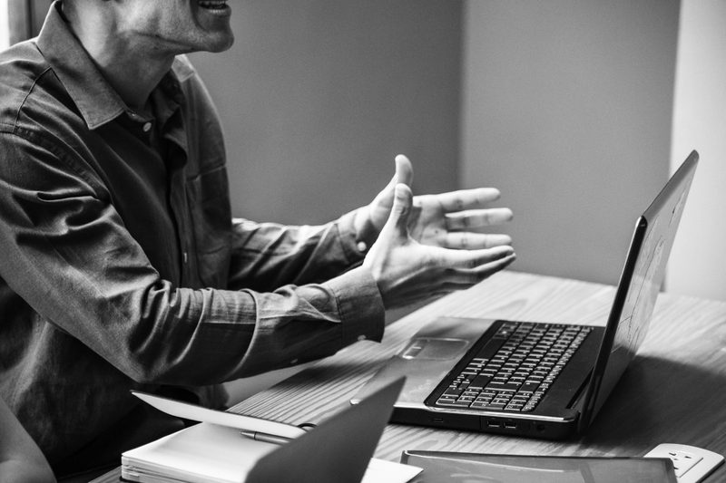 fotografía en blanco y negro. Hombre explicando con portátil
