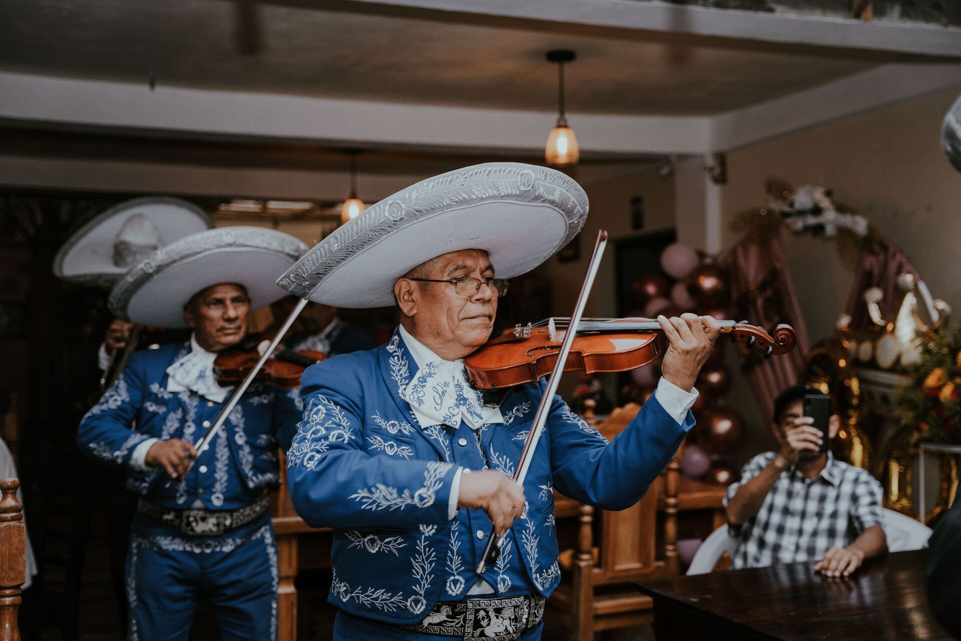 Mariachis en Bogotá tocando violines durante una celebración tradicional.