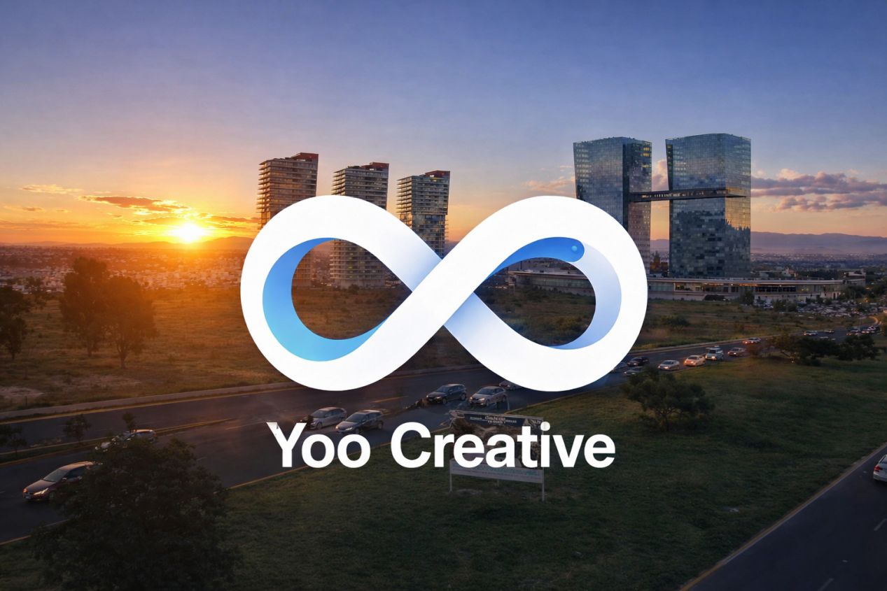 logo yoo creative. de fondo rascacielos en una ciudad al atardecer
