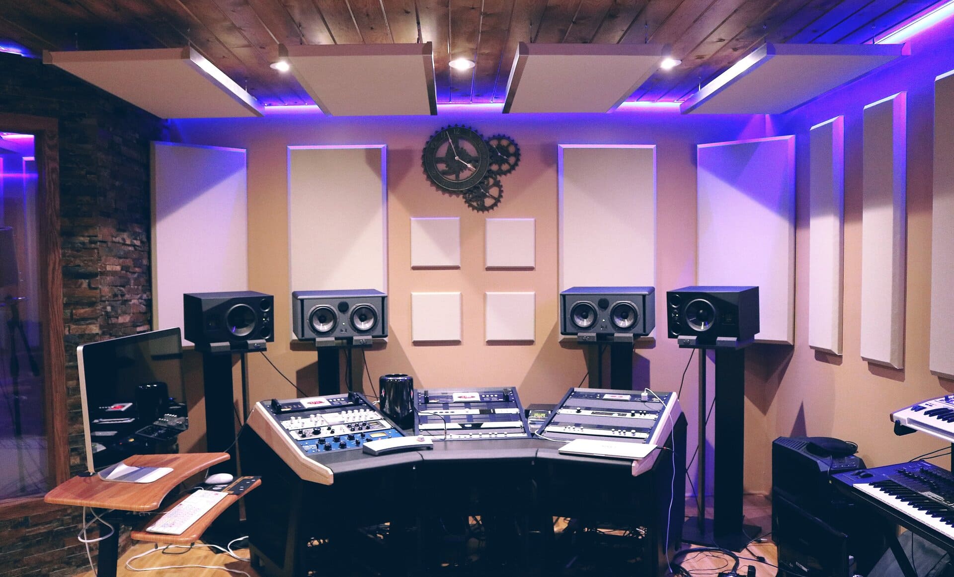 Estudio de grabación profesional con paneles acústicos, altavoces y mesa de mezclas.